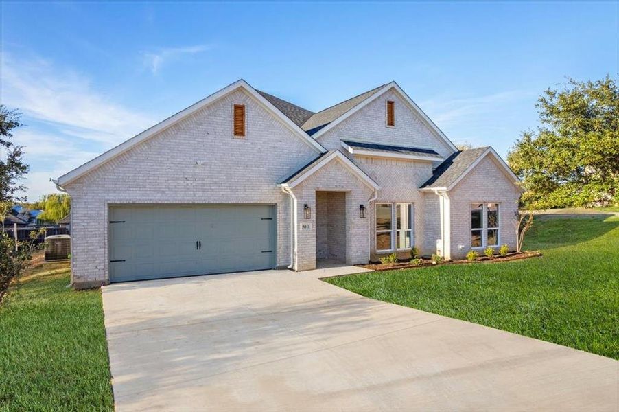 View of front of house featuring a garage and a front yard