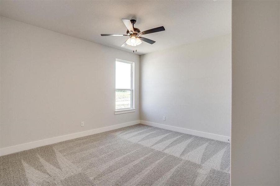 Unfurnished room featuring carpet floors and ceiling fan