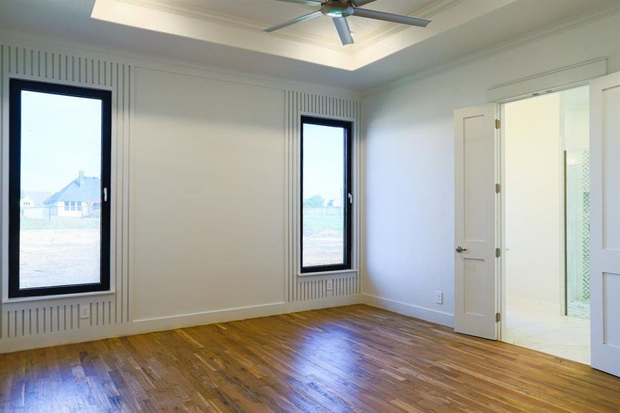 Empty room featuring a wealth of natural light, ceiling fan, and hardwood / wood-style floors