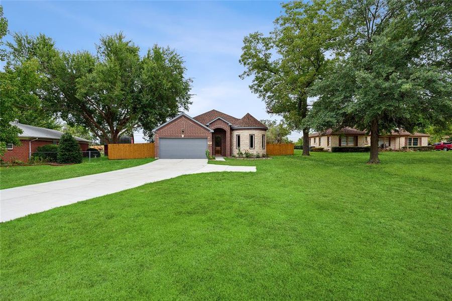 View of front of house featuring a garage and a front lawn