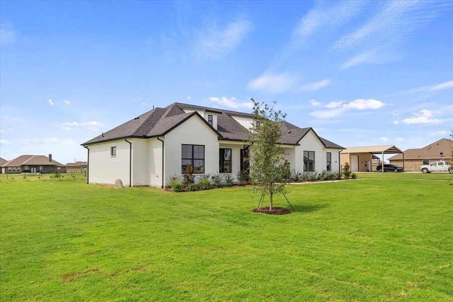 Rear view of house featuring a yard