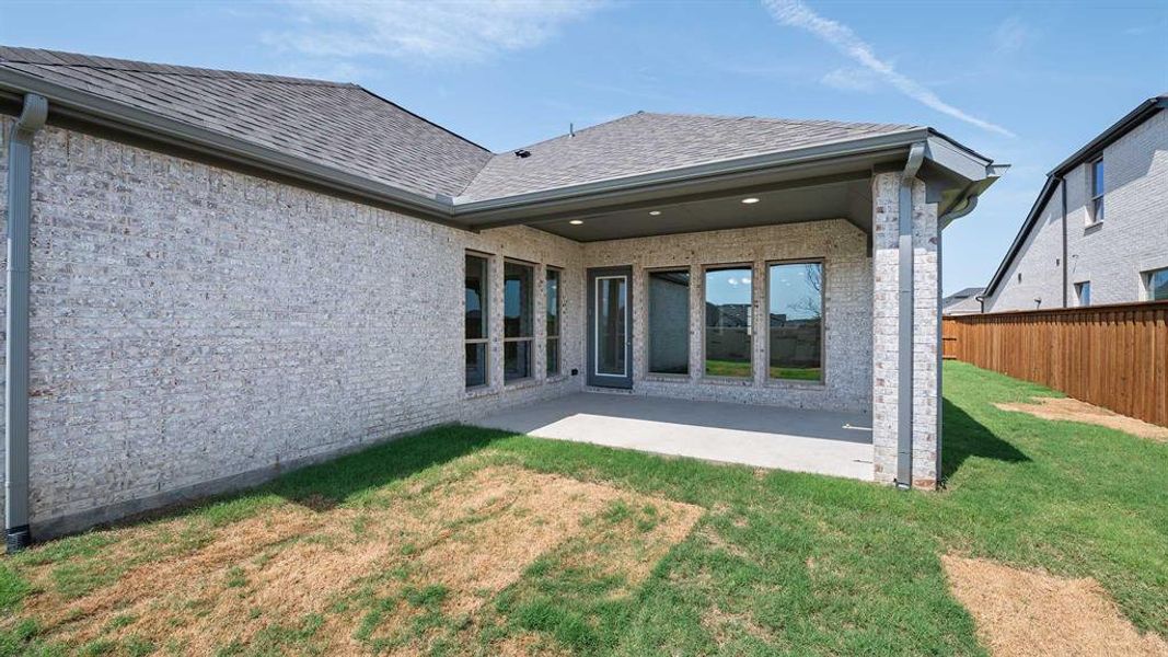 Rear view of property with a yard and a patio area