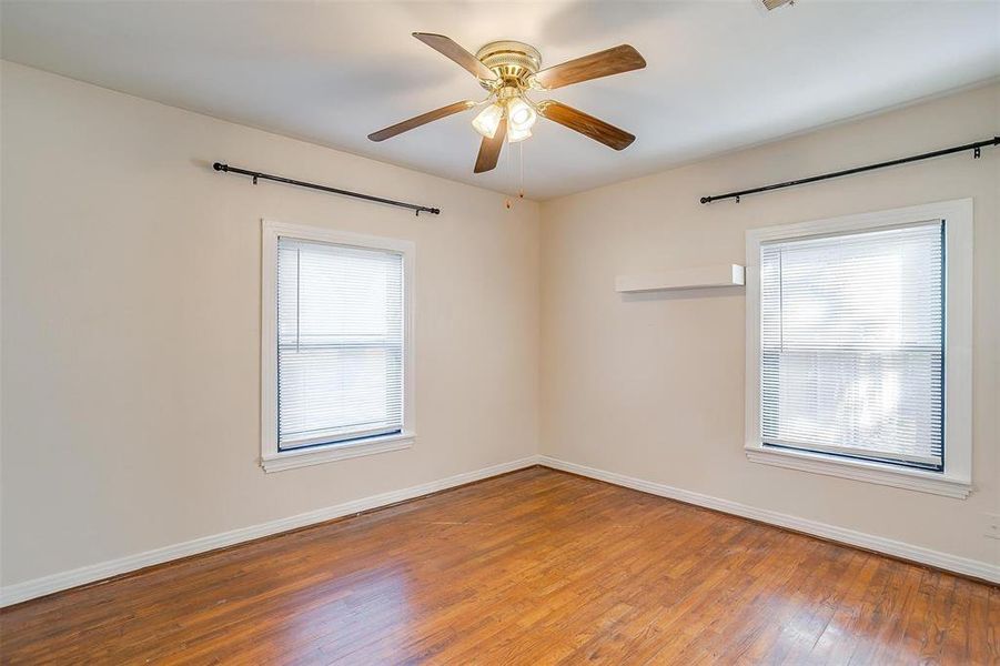 Spare room featuring ceiling fan, a healthy amount of sunlight, and wood-type flooring