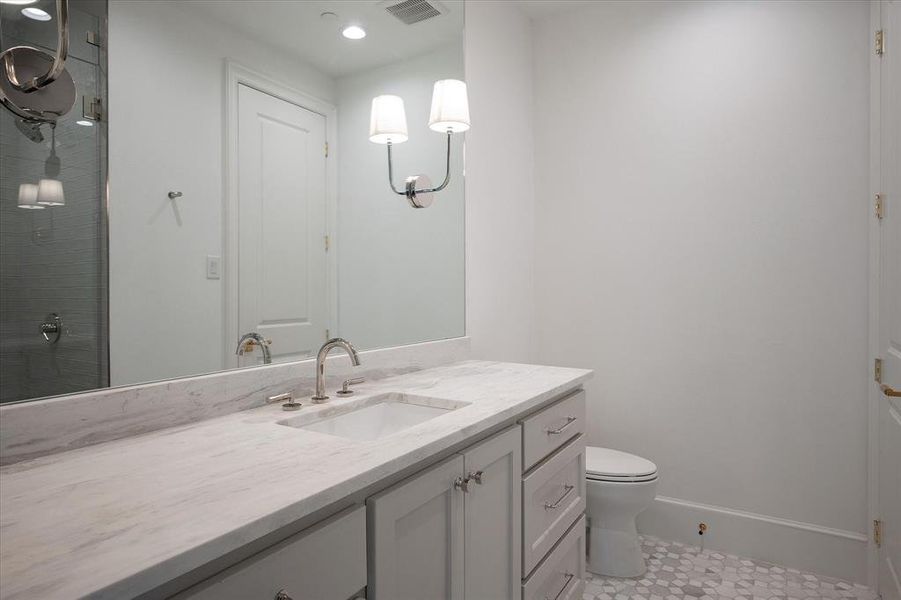 Bathroom with vanity, toilet, and a shower