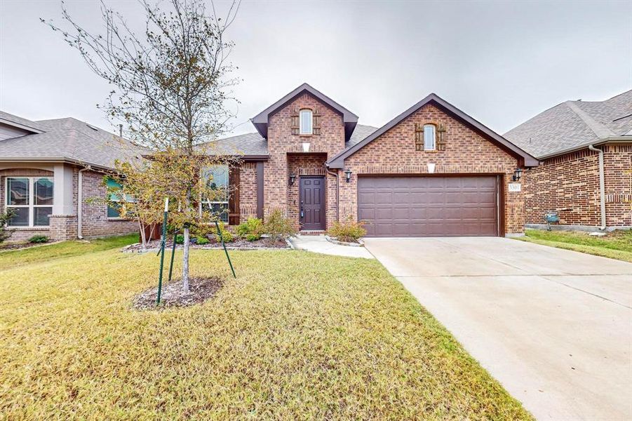 View of front of house featuring a garage and a front yard