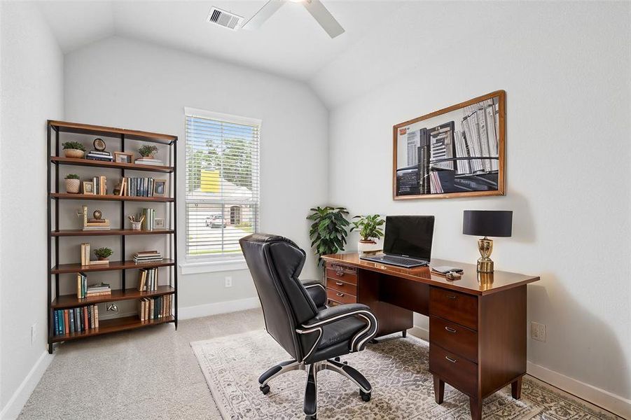 Nestled away quietly in the front of the home is the handsome home office! Featuring high ceilings, ceiling fan, custom paint, plush carpet flooring, and large windows with privacy blinds!