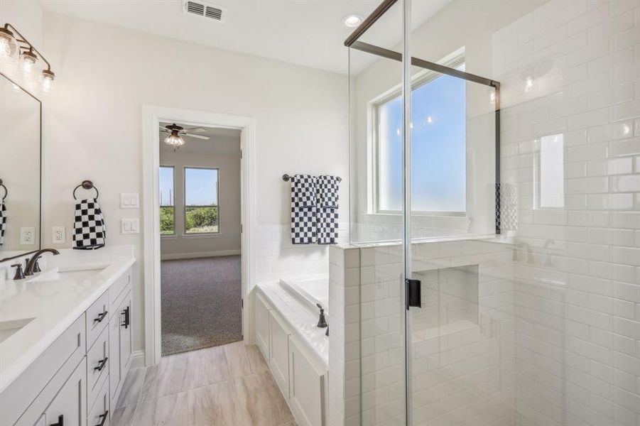 Bathroom featuring dual vanity, shower with separate bathtub, ceiling fan, and tile patterned flooring