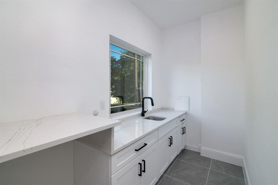 Washroom with sink and dark tile patterned flooring