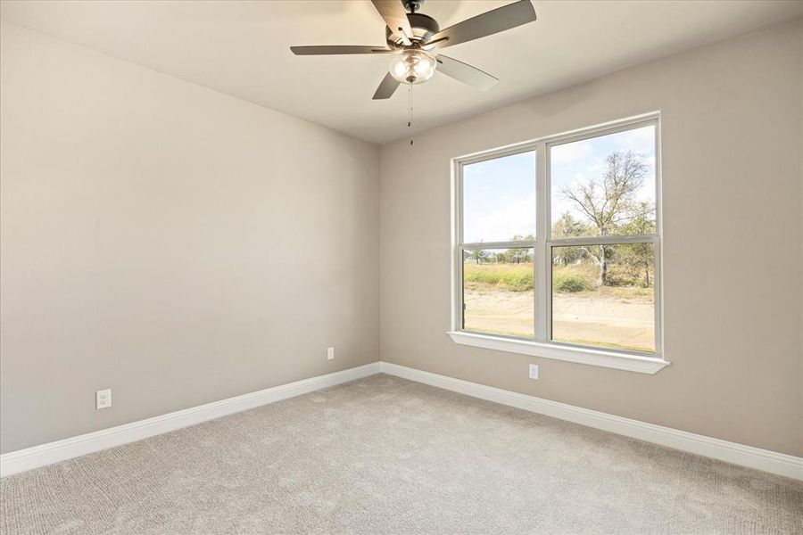 Carpeted empty room with ceiling fan