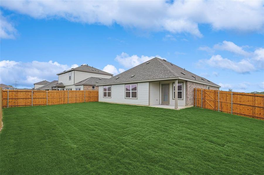 Back of house featuring a patio area and a lawn