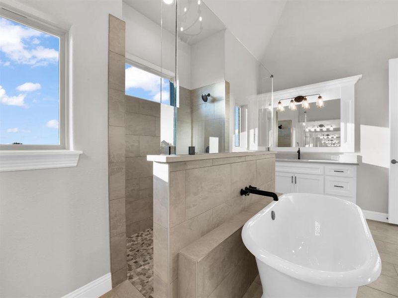 Bathroom featuring tile flooring, independent shower and bath, vanity, and lofted ceiling