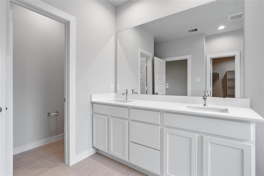 This primary bathroom is definitely move-in ready! Featuring a framed walk-in shower with tile surround, separate garden tub for soaking after a long day with custom tile detailing, light cabinets with light countertops, spacious walk-in closet with shelving, high ceilings, custom paint, sleek and modern finishes.