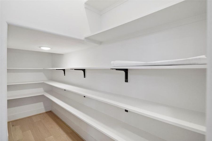 Spacious walk-in pantry with ample shelving to effortlessly organize your groceries, gadgets, and more.