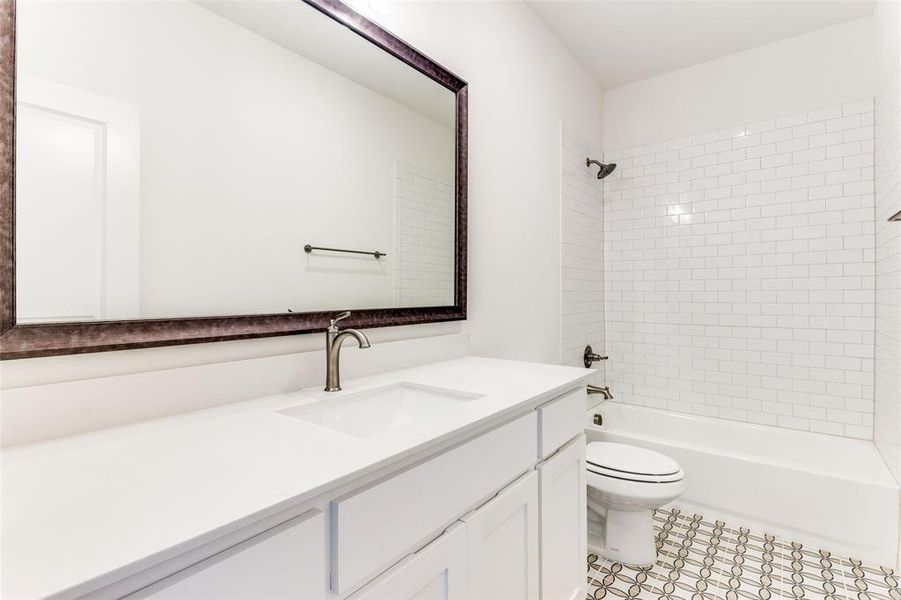 Full bathroom featuring tiled shower / bath, vanity, and toilet