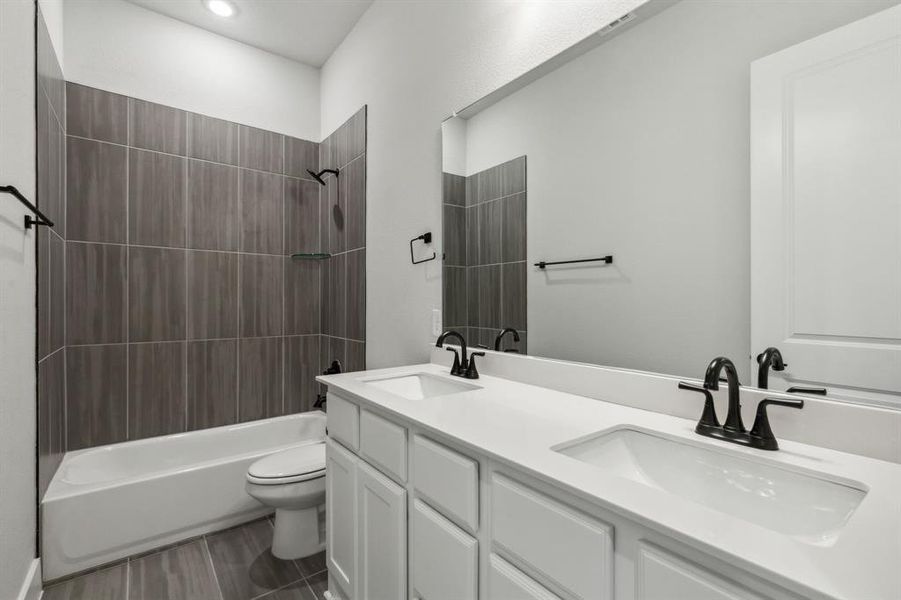 Full bathroom featuring tiled shower / bath, toilet, hardwood / wood-style flooring, and vanity