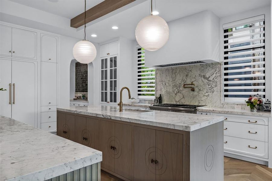 Kitchen with a healthy amount of sunlight, sink, decorative light fixtures, and white cabinets