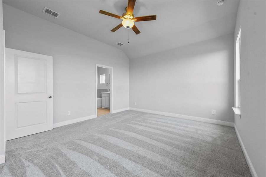 Carpeted room with ceiling fan and lofted ceiling