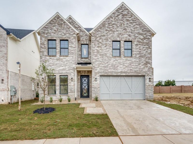 View of front of property with a garage and a front yard