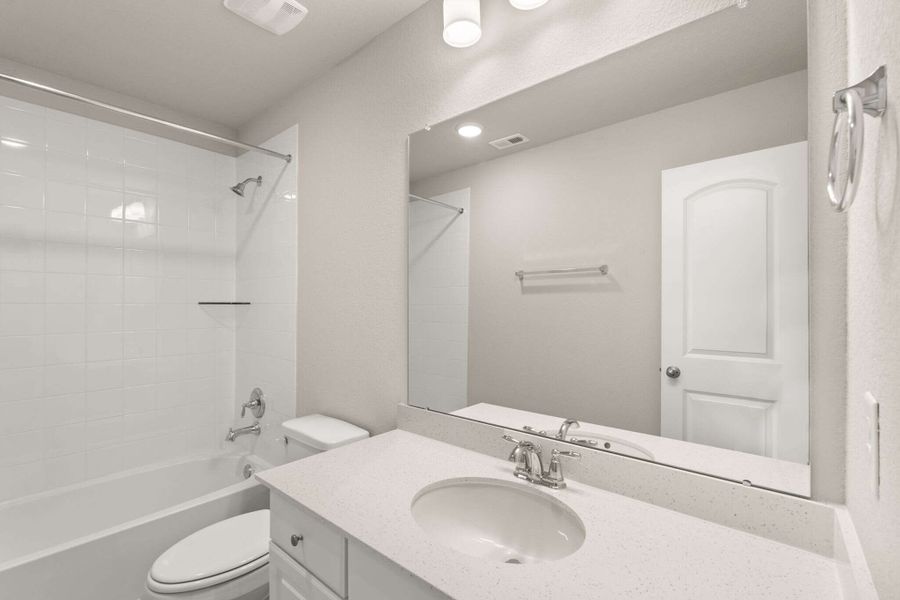 The secondary bath features white cabinetry with light countertops and a shower/tub combo.