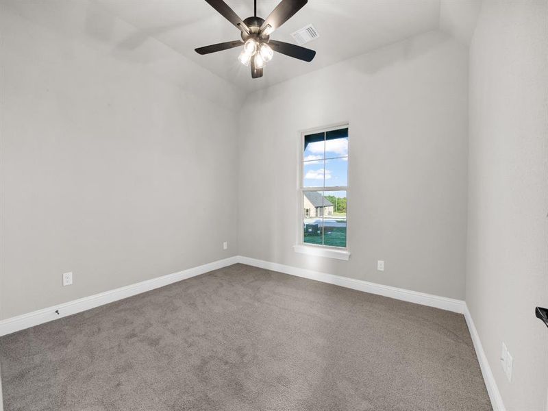 Carpeted spare room with ceiling fan and lofted ceiling