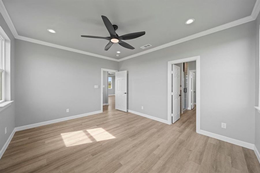 Unfurnished bedroom with light wood-type flooring, ceiling fan, and ornamental molding