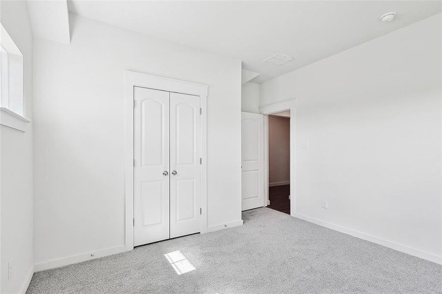 Unfurnished bedroom with a closet and light carpet