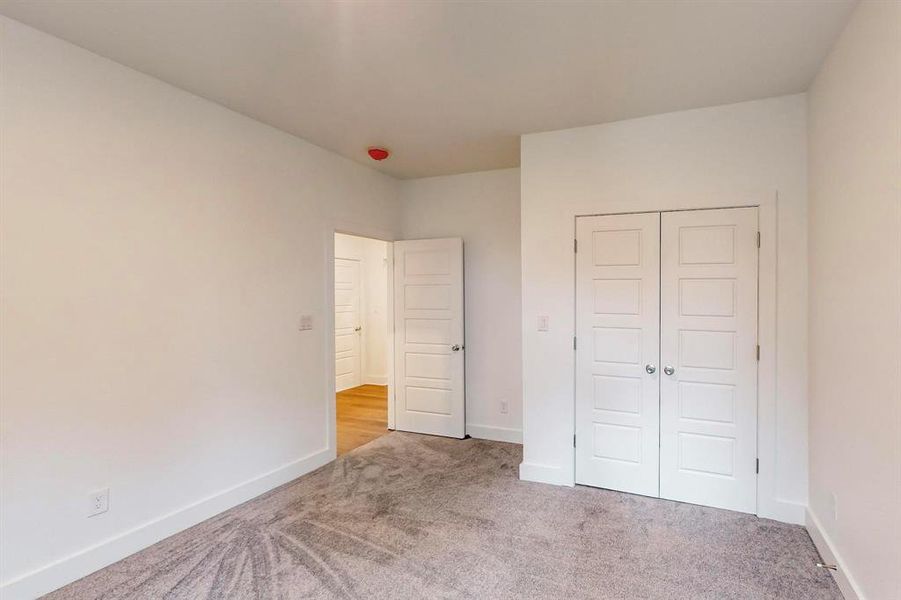 Unfurnished bedroom with a closet and light carpet