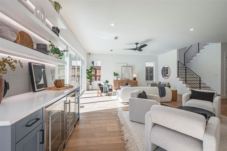 Living room featuring ceiling fan, light hardwood / wood-style floors, and beverage cooler