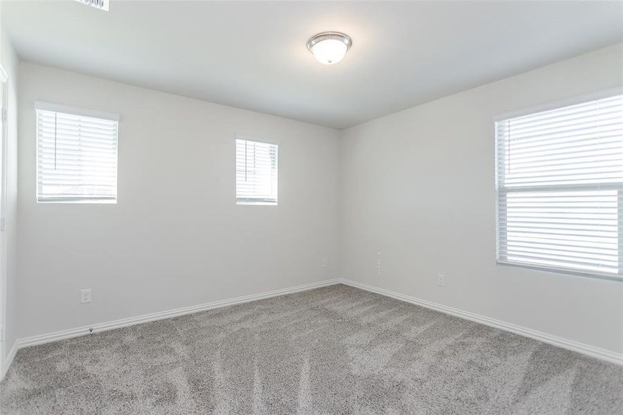 One of the bedrooms upstairs featuring light colored carpet and plenty of natural light