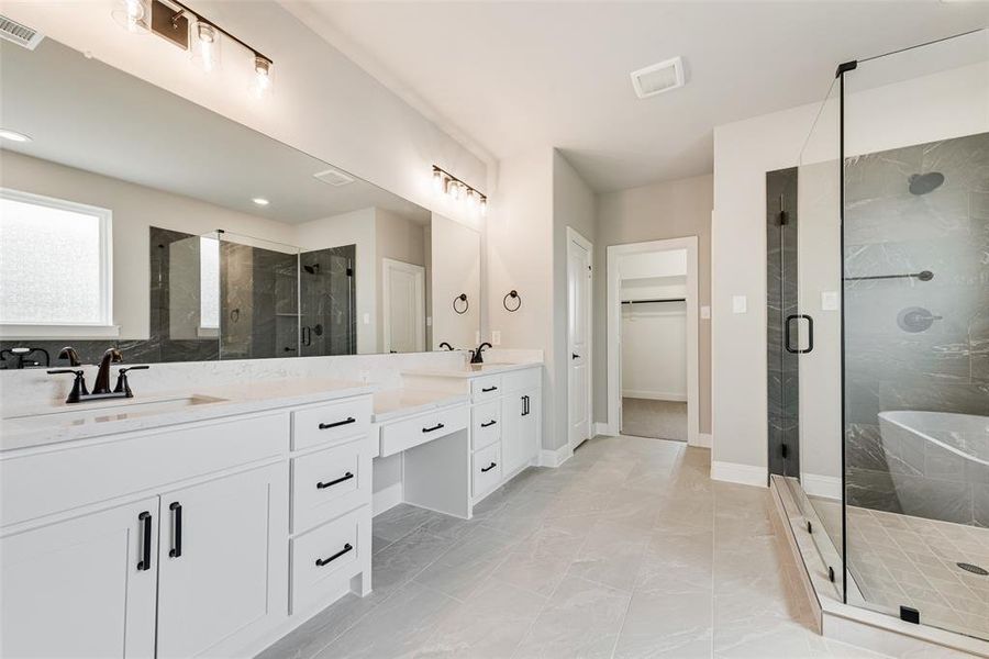 Bathroom featuring a shower with door and vanity