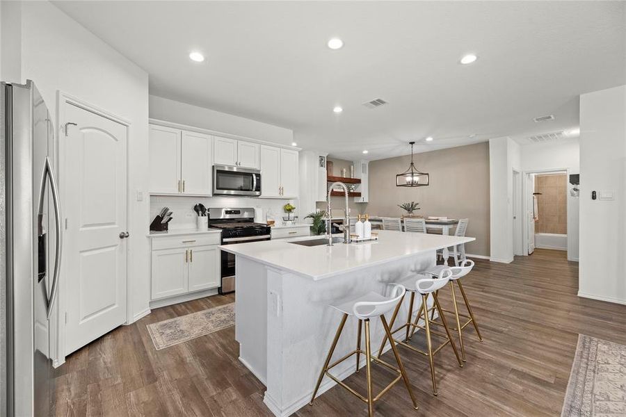 Crisp white cabinets with updated hardware provide a clean and timeless look, enhancing the sense of brightness and openness in the space.