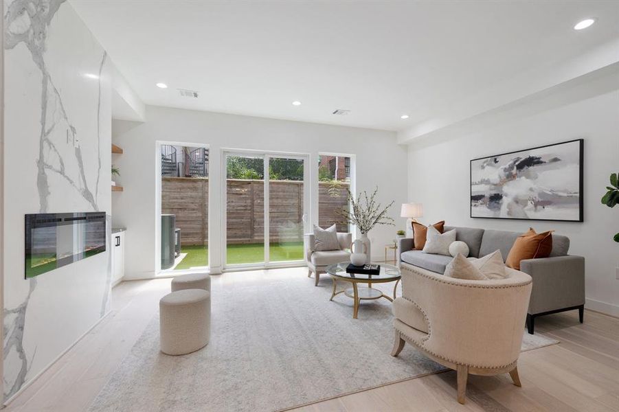 On the other side of the living area you will find an oversized electric fireplace accented by book matched slabs.