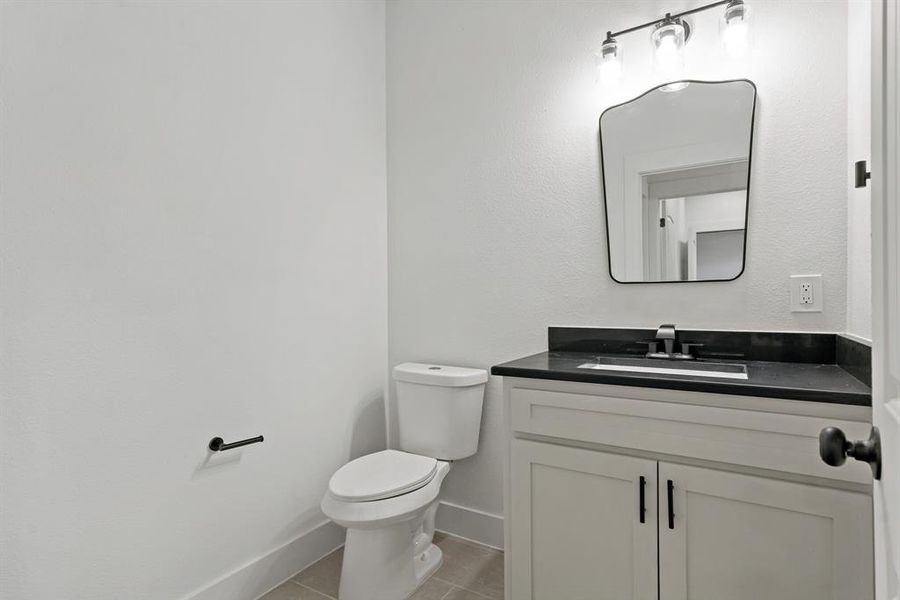 Bathroom featuring tile patterned flooring, toilet, and vanity