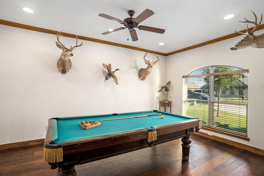 Recreation room with ornamental molding, pool table, dark hardwood / wood-style floors, and ceiling fan