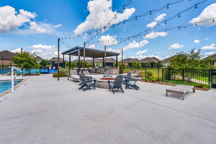 View of patio with an outdoor fire pit, community pool, and a pergola