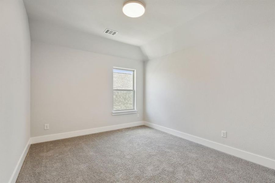 Carpeted spare room with lofted ceiling