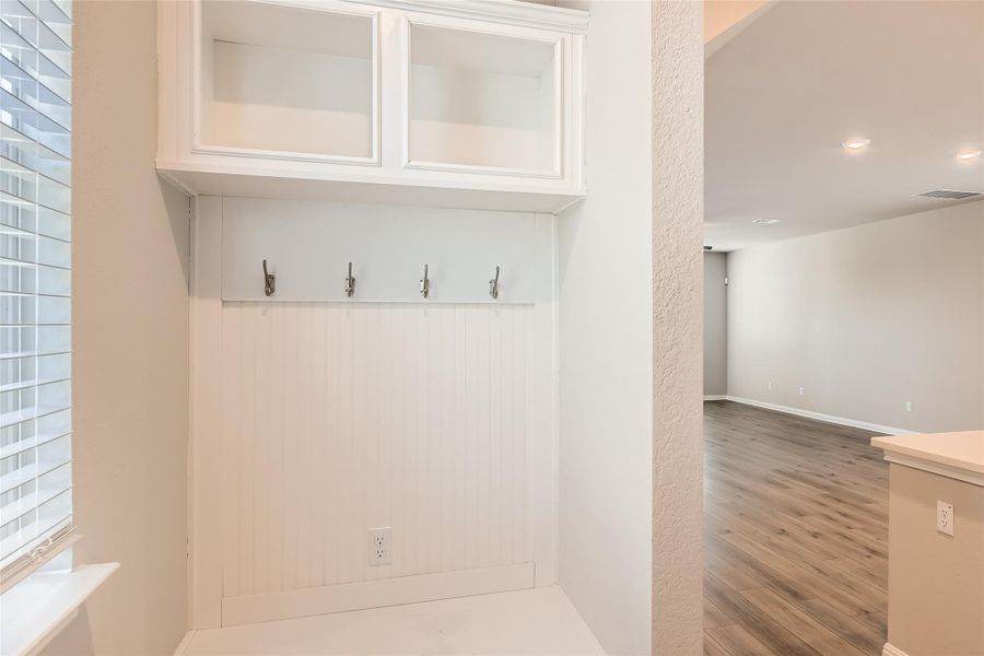 The garage entry boasts charming mud room bench seating with cubbies and hooks.