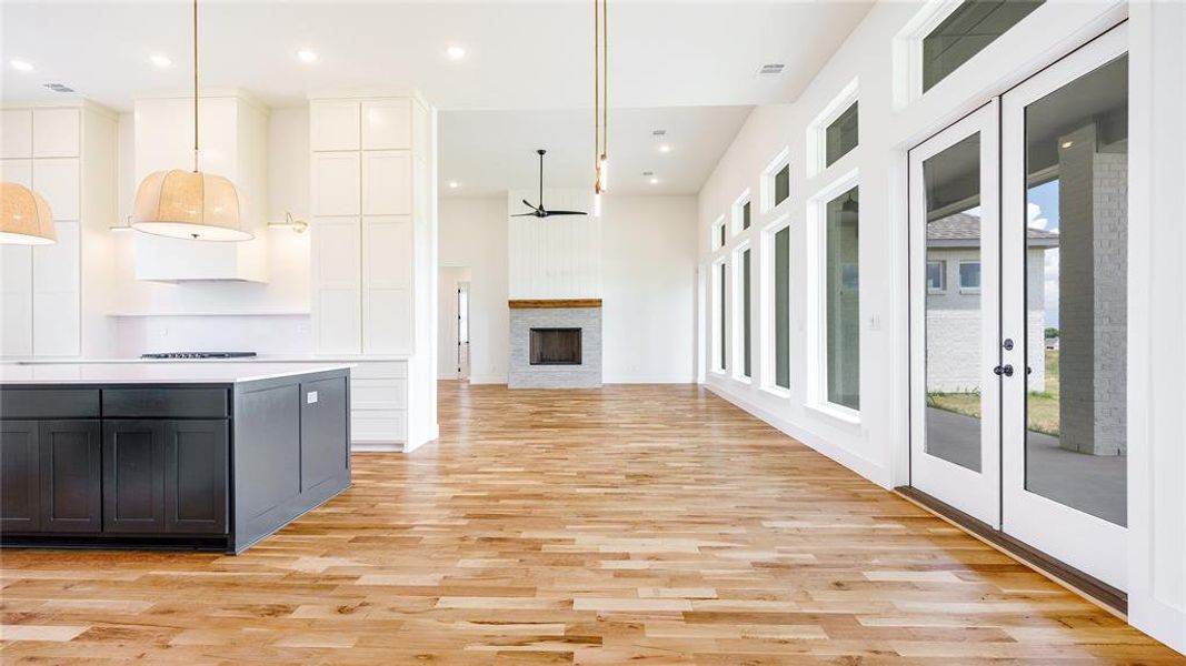 Kitchen featuring white cabinetry, french doors, plenty of natural light, and light hardwood / wood-style flooring