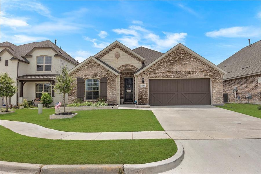 French country home featuring a garage and a front yard