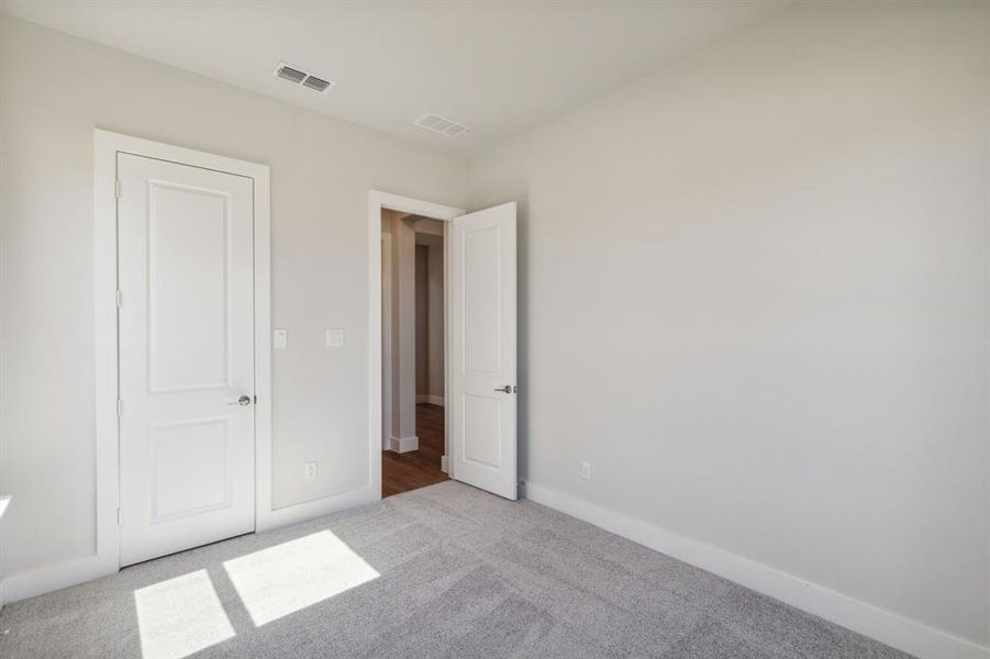 Unfurnished bedroom featuring light colored carpet