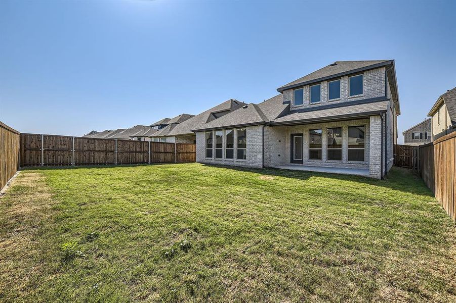 Rear view of property with a patio and a lawn