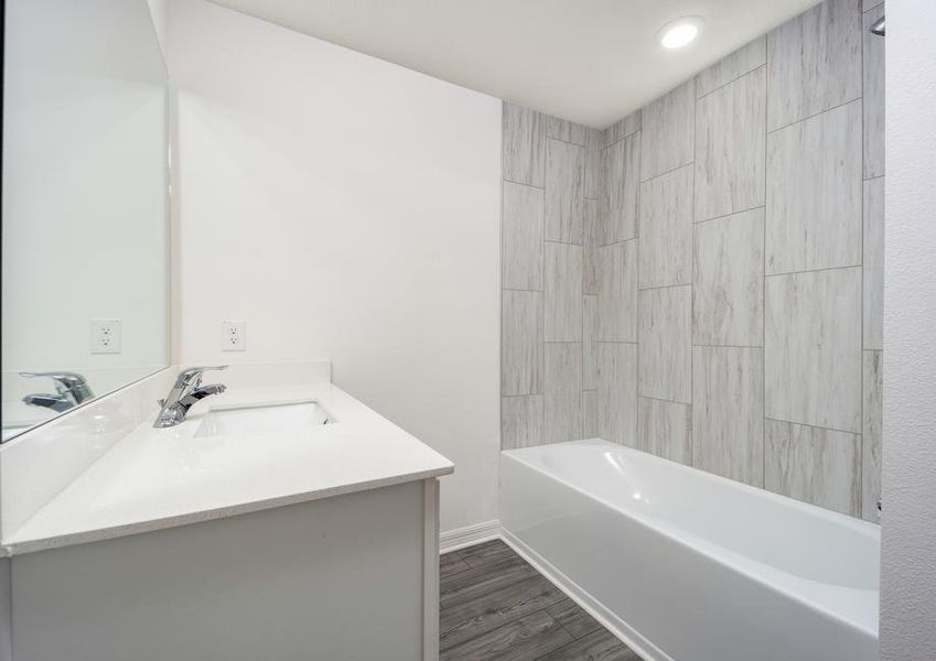 The secondary bathroom features a shower/tub combination with tile detail