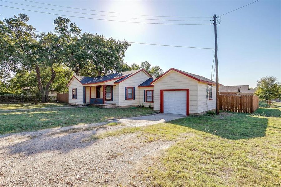 Single story home featuring a front yard and a garage