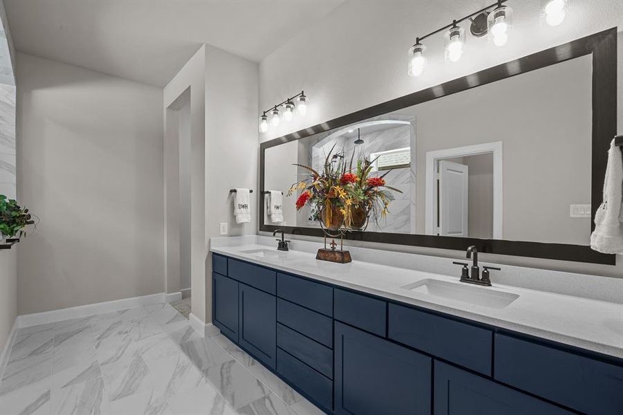 Navy cabinets with quartz counters and dual sinks at Master