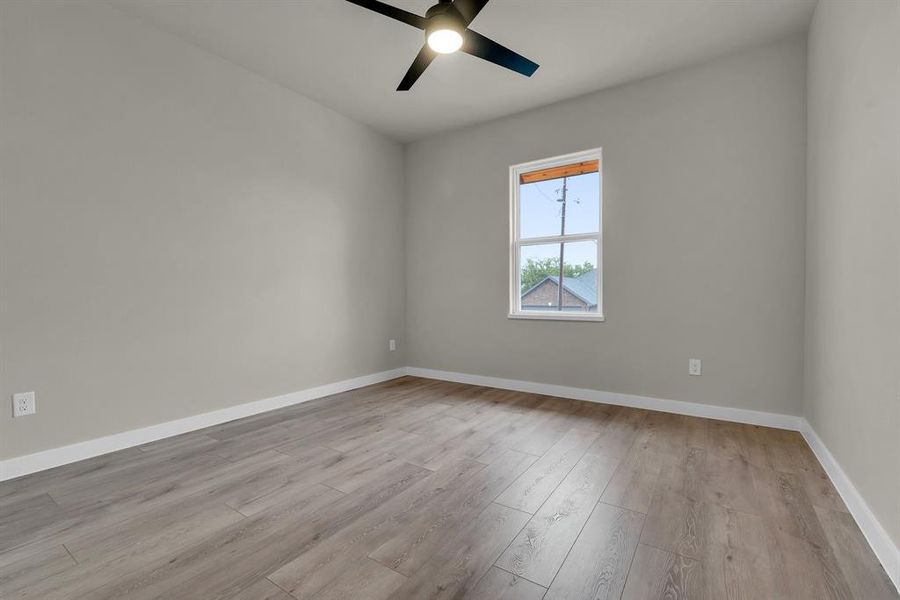 Unfurnished room with light wood-type flooring and ceiling fan