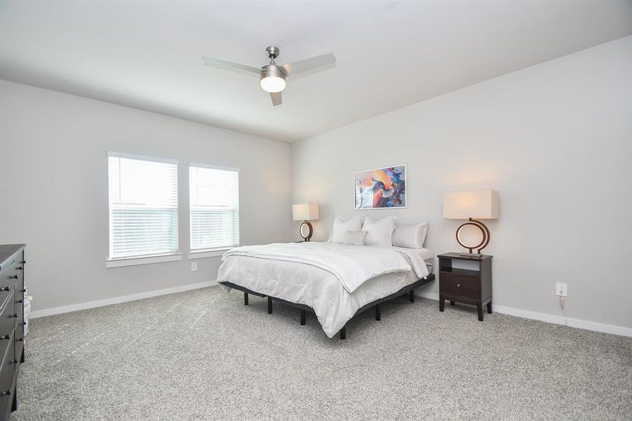 Bedroom with a bed and large windows allowing natural light.