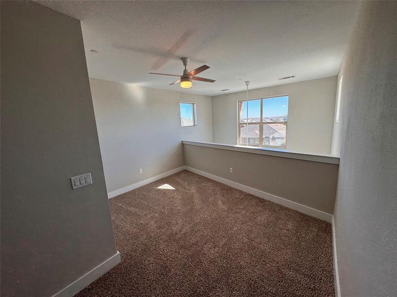 Carpeted empty room with ceiling fan