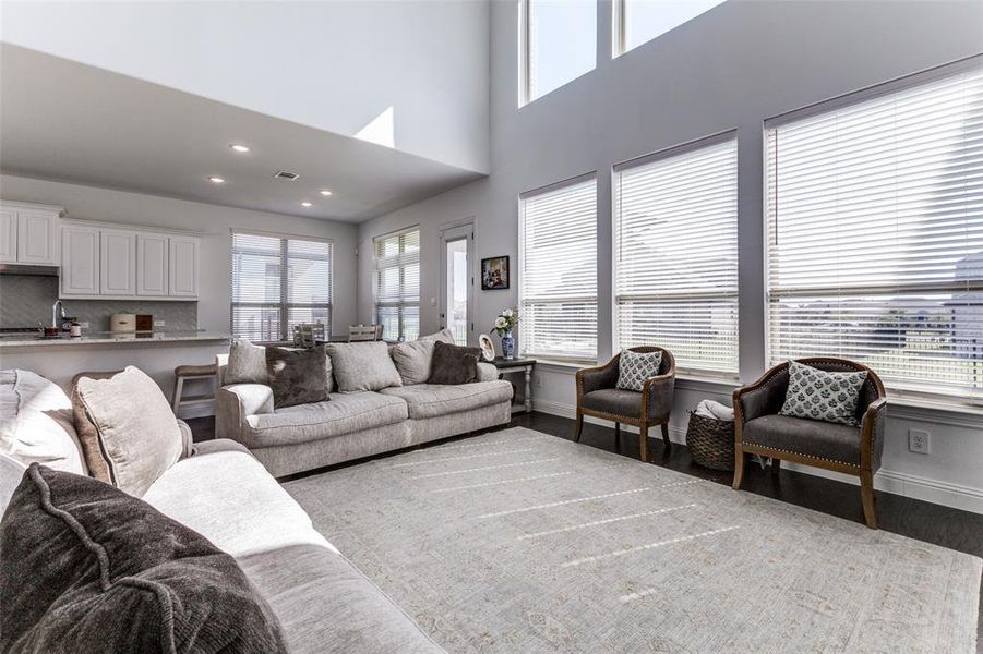 Living room with a towering ceiling and lwood floors