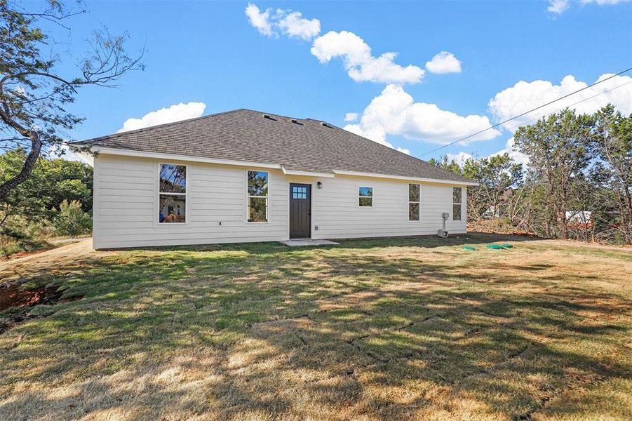 Rear view of property featuring a lawn