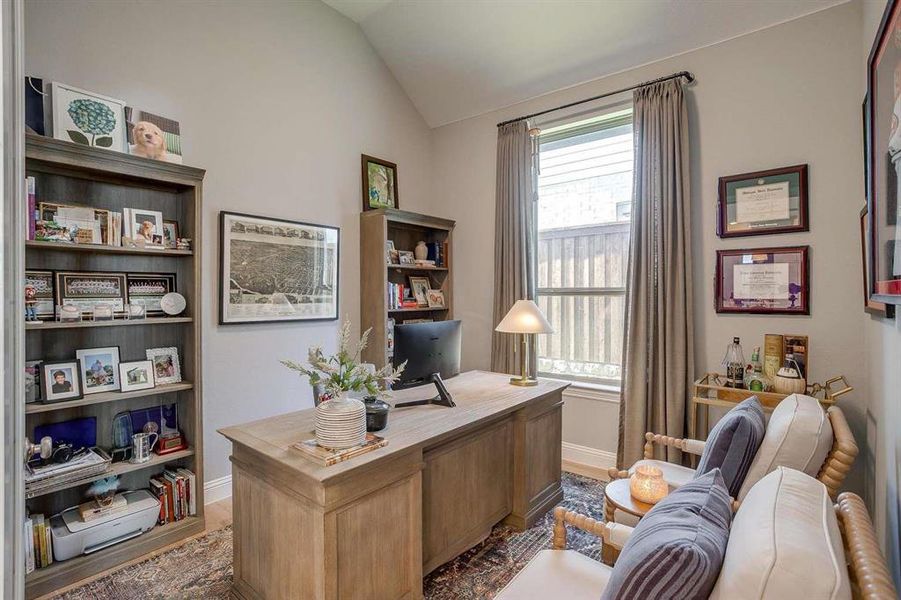 Home office featuring hardwood / wood-style flooring and vaulted ceiling